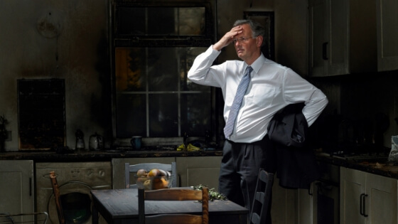 man standing in kitchen with smoke damage